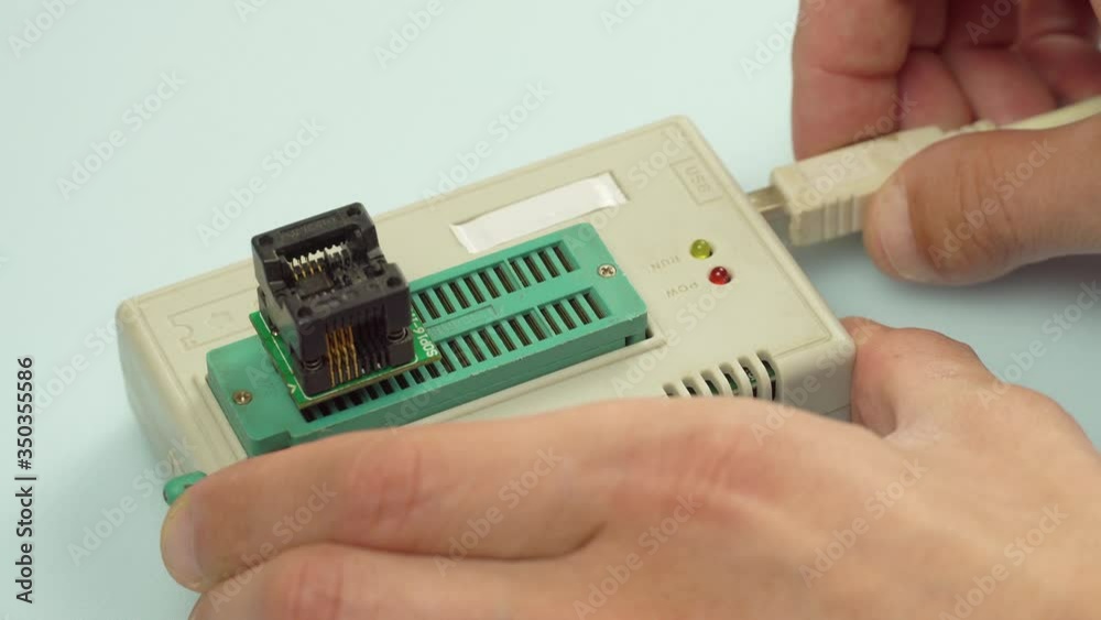The master inserts a power cable into the programmer, the indicator lights up, for programming the chip. The master inserts a power cable into the programmer, the indicator lights up, for programming the chip.