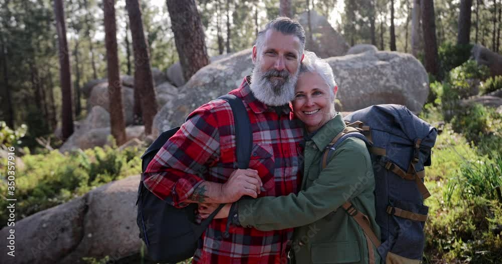 Close up senior couple hugging posing for photo in forest Close up senior couple hugging posing for photo in forest