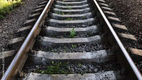 A long railway goes into the distance. Slowly raising the camera over the rails. Railway in nature