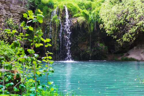 Waterfall that flows into a blue lake with clear water