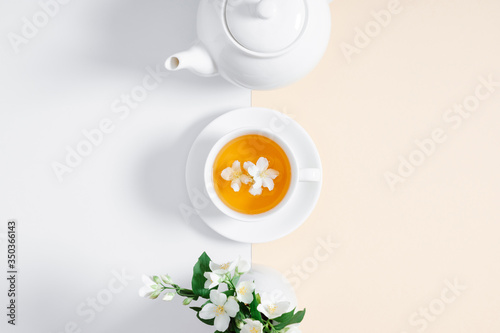 Jasmine flowers and teapot on white background. Herbal tea of jasmine flower. Jasmine tea concept. Flat lay, top view, copy space