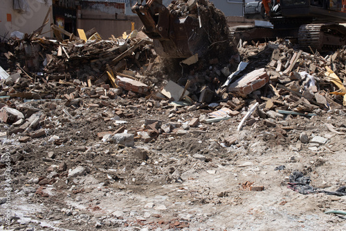 excavator loading debris of a destroyed building