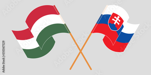 Crossed and waving flags of Hungary and Slovakia