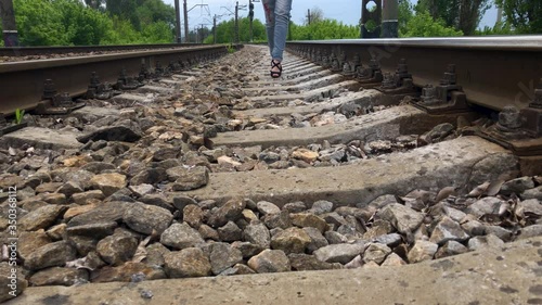 A girl walking on the rails on the high heels. Sexy legs in high heels. A girl walks on the railway. Goes towards.