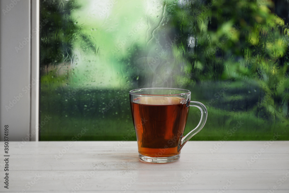 Cup of hot drink near window on rainy day Cup of hot drink near window on rainy day