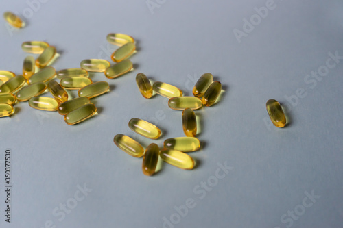Capsules with fish oil on a blue background. Healthy lifestyle concept.