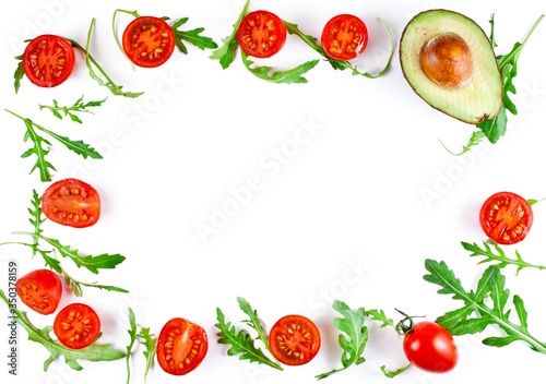 Frame made of halved cherry tomatoes with avocado and rucola leaves isolated on a white background. Copy space. Top view.