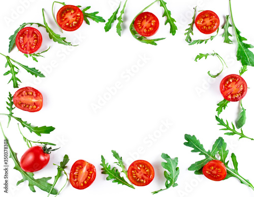 Frame made of halved cherry tomatoes and rucola leaves isolated on a white background. Copy space. Top view.