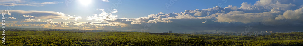 Panorama of the city behind the forest on a spring day. Big panorama with green Park and summer sun - Moscow, Russia, Butovo forest