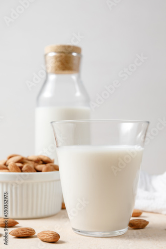 Almond milk in a glass and a glass bottle - alternative dairy