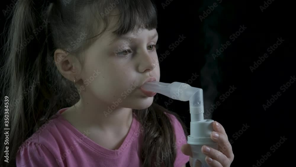 Inhalation with a nebulizer. A little girl on a black background conducts procedures with a nebulizer. Inhalation with a nebulizer. A little girl on a black background conducts procedures with a nebulizer.