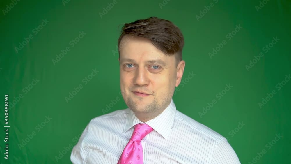 Happy big man takes off his mask and is overjoyed with a wonderful smile on a green background day