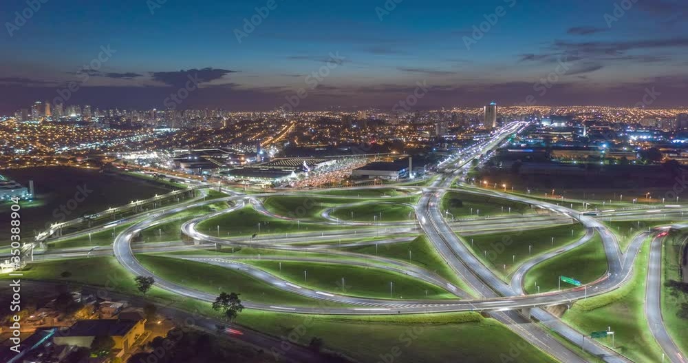 Aerial Hyperlapse of Roundabout in Ribeirao Preto at dusk. Cars and illuminated city in the background