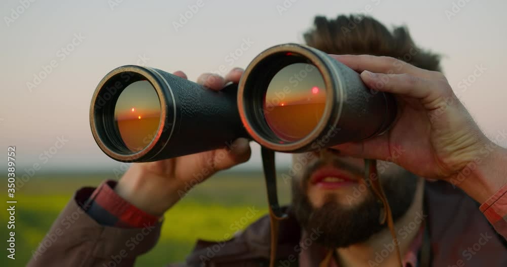 The guy is looking through binoculars. Hiking in the forest. 4k The guy is looking through binoculars. Hiking in the forest. 4k