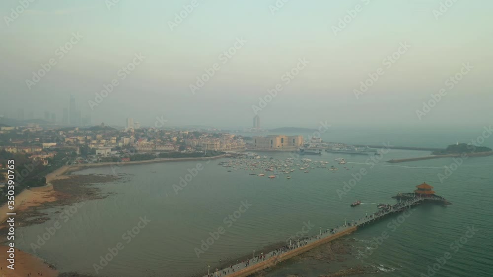 qingdao city sunset time famous beach bay pagoda crowded pier aerial panorama 4k china qingdao city sunset time famous beach bay pagoda crowded pier aerial panorama 4k china