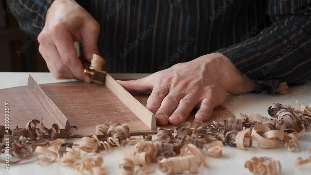 a male luthier pyramiding braces on the back side of guitar in workshop