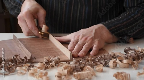 a male luthier pyramiding braces on the back side of guitar in workshop photo