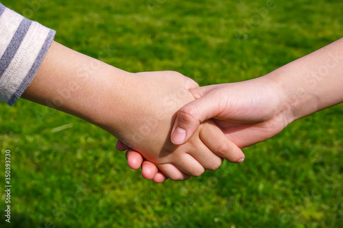 Children shaking hands　握手する子供 © Kana Design Image
