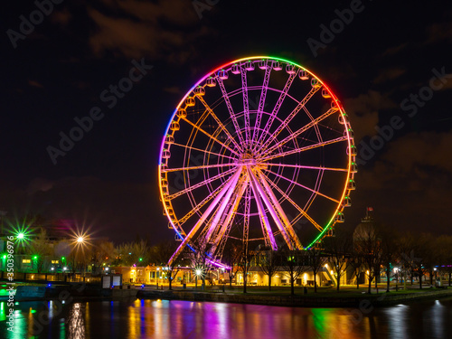 The ferris wheel of the old port of Montreal with the colors of the rainbow concerning the covid-19