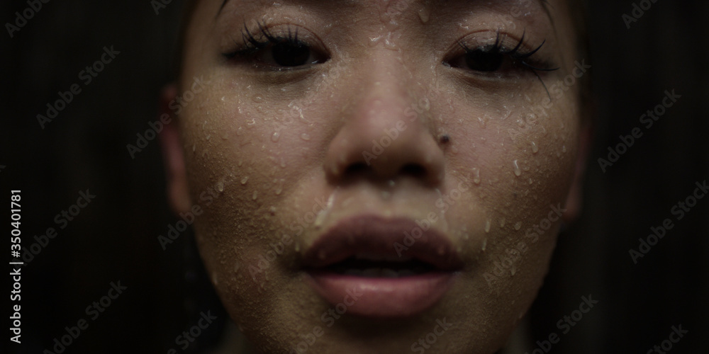 Beautiful young woman covered in drops of water from a shower she just took at an outdoor spa while on vacation