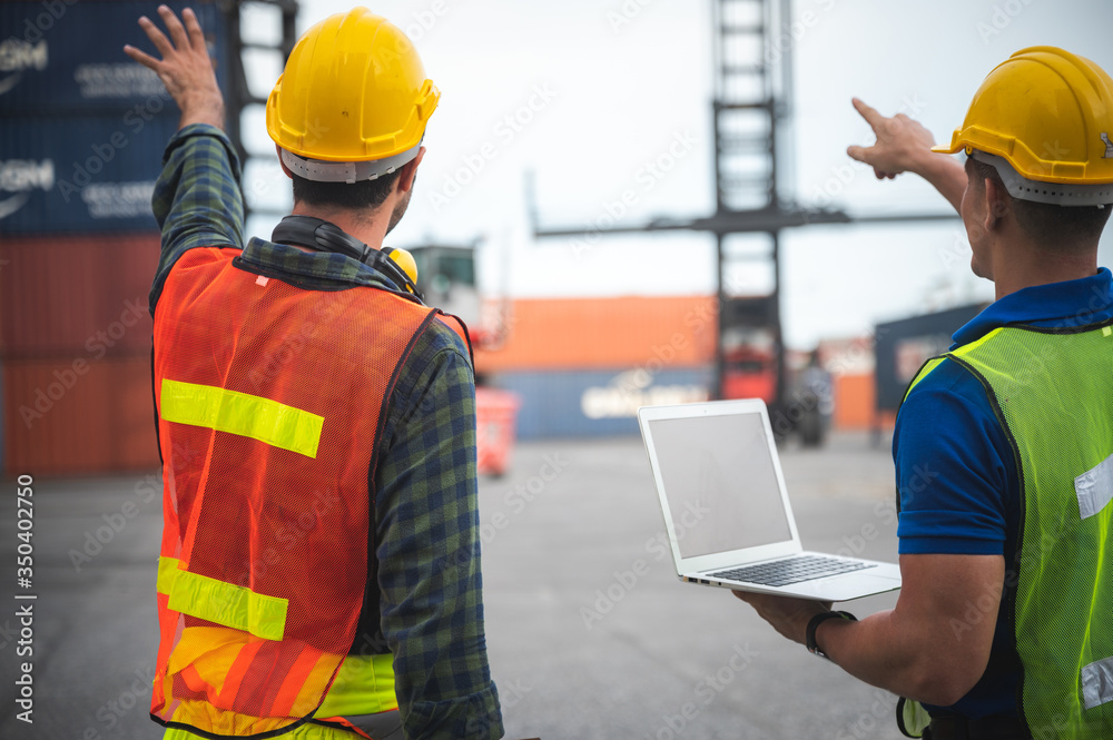 Foreman engineer working in container yard, Quality control Inspector using laptop for checking on container site, logistic store for import and export concept Foreman engineer working in container yard, Quality control Inspector using laptop for checking on container site, logistic store for import and export concept