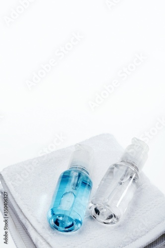 Bottles of bathing gel on top of towels