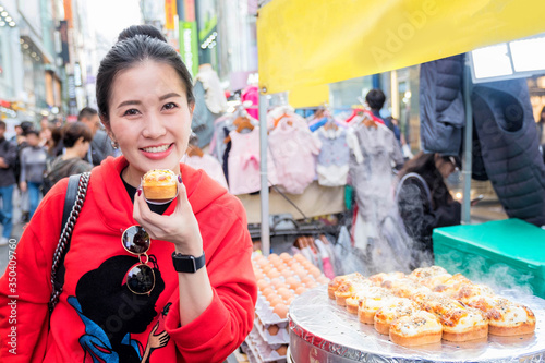 Photography Woman eating Egg bread with almond, peanut and sunflower seed at Myeong-dong str