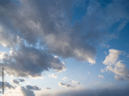 Beautiful bizarre clouds fly through the evening blue sky. Summer day