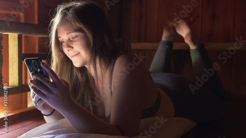 Young women using smartphone smiling, giggling and laughing while texting and playing videos Portrait of a beautiful girl on phone relaxing, texting, flirting, messaging and communicating friend in 4k