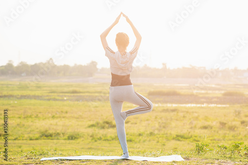 Fototapeta Naklejka Na Ścianę i Meble -  Young girl practicing yoga in the nature.female happiness.