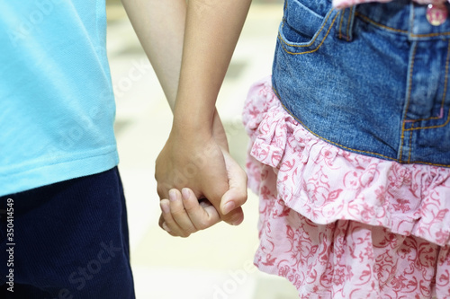 Fototapeta Naklejka Na Ścianę i Meble -  Boy and girl standing hand in hand