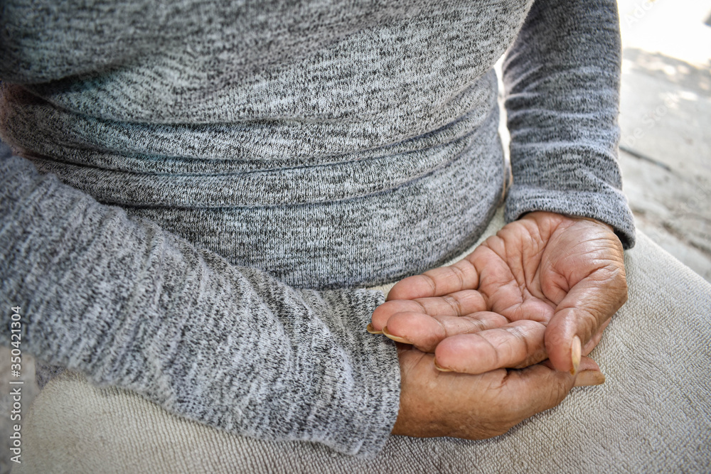 Fototapeta premium The hand of the sick old woman rests on the lap. Mental health care at home.