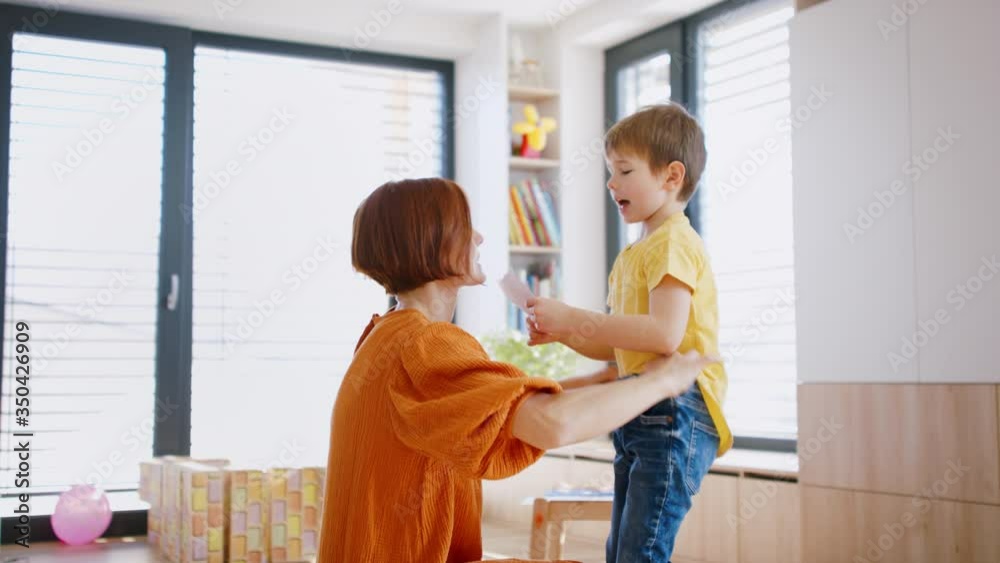 Mother with small children in bedroom in the morning at home.