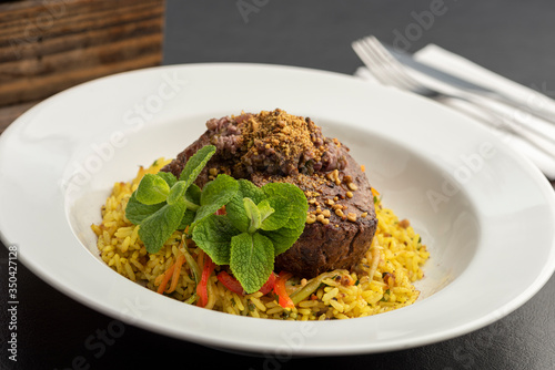 Plate with steak tenderloin and rice with spices ans saffron.