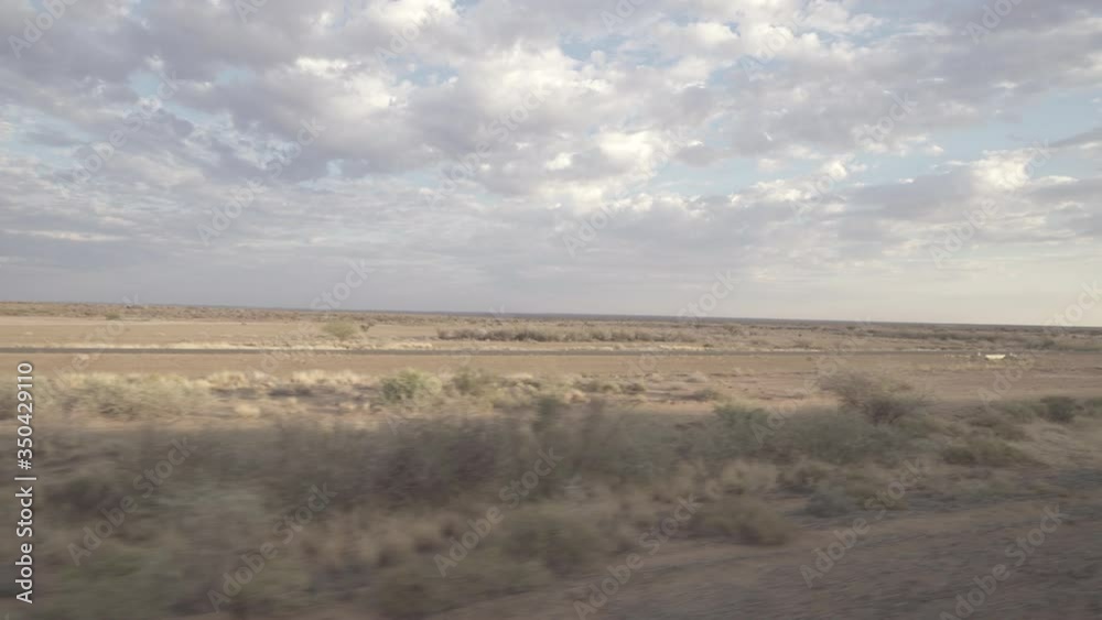 Panning shot of landscape from train window against cloudy sky, beautiful rail journey at remote location - Swakopmund, Namibia Panning shot of landscape from train window against cloudy sky, beautiful rail journey at remote location - Swakopmund, Namibia