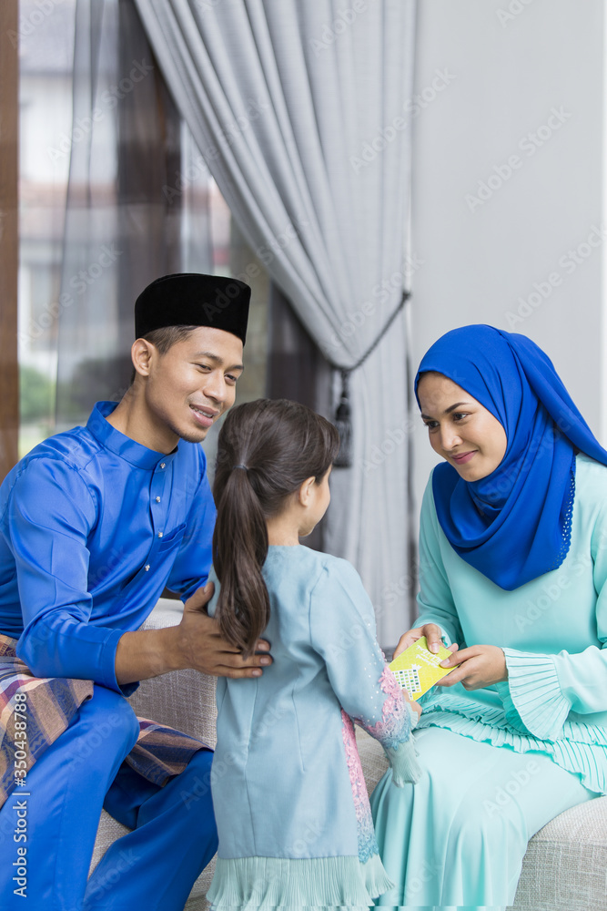 Φωτογραφία Muslim girl receiving green envelope from parents during Eid al-Fitr