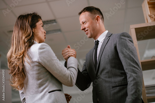 Businessman and businesswoman in office. Young woman and man flirting in office.