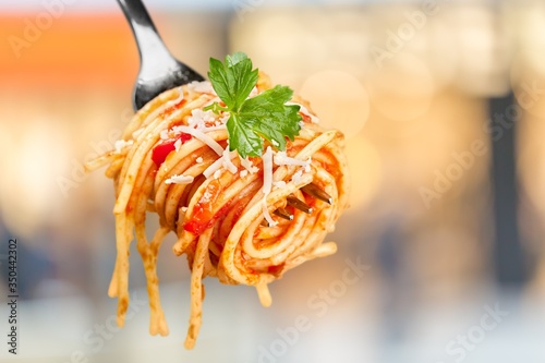 Metal fork with delicious spaghetti and sauce