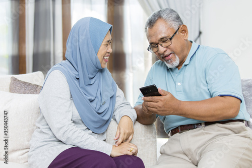 Senior couple checking the smartphone photo