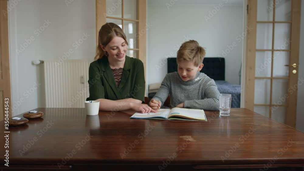 Responsible Sister Homeschooling Her Bro with an Open Worksheet by the Table Responsible Sister Homeschooling Her Bro with an Open Worksheet by the Table
