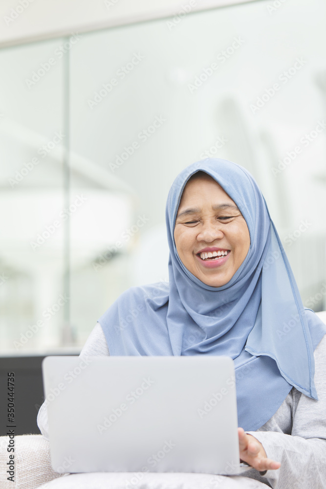 Senior woman smiling while using a laptop Senior woman smiling while using a laptop