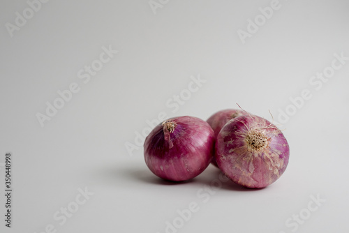Three Peruvian red onions with white background