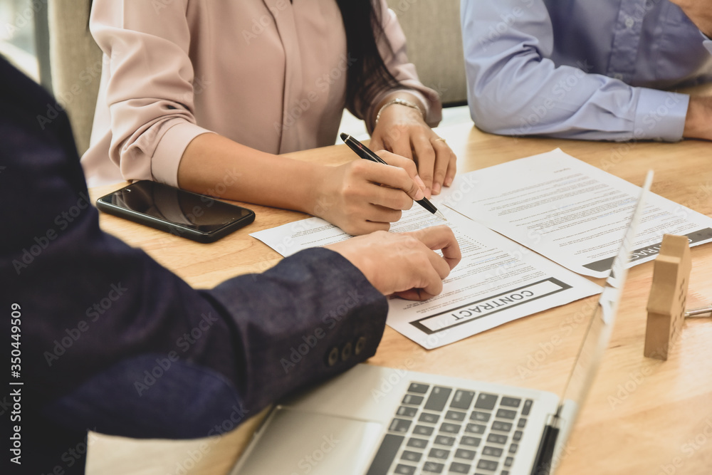 Women sign on document agreement to buying home