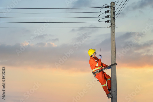 Electricians are climbing on electric poles to install and repair power lines.electricians work with high voltage electricity.