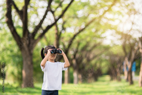 Happy child girl playing with binoculars. explore and adventure concept © FAMILY STOCK