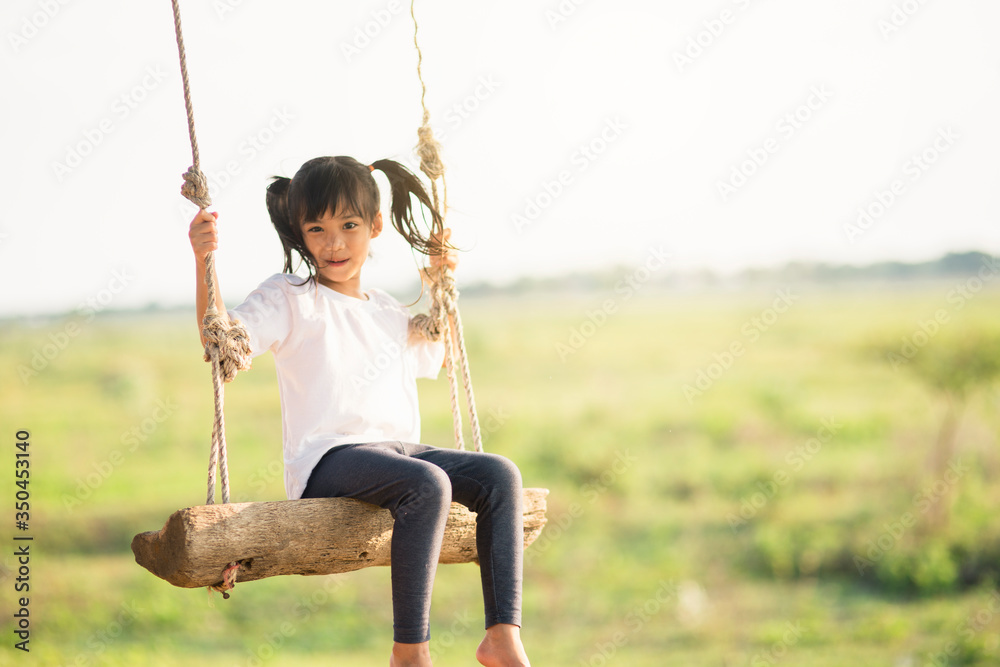 Little girl is swinging at play ground