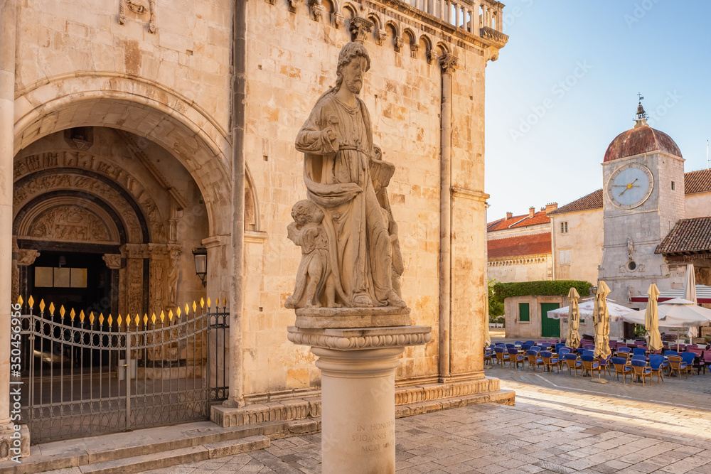 Statue of St Lawrence with Clock tower at background in Trogir, Croatia