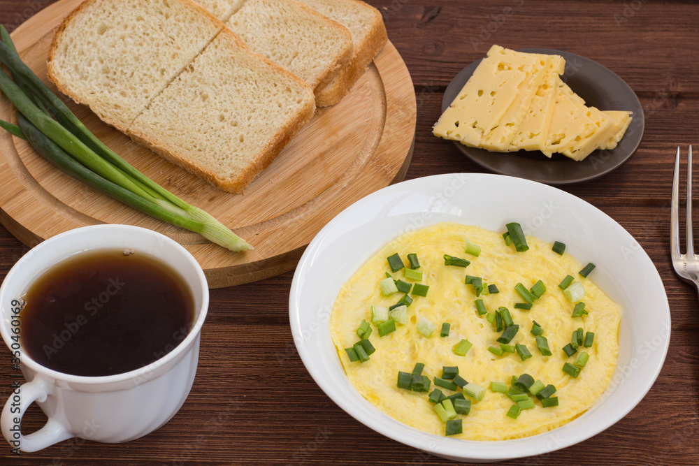 breakfast omelet tea cheese bread and onion on a wooden table breakfast omelet tea cheese bread and onion on a wooden table