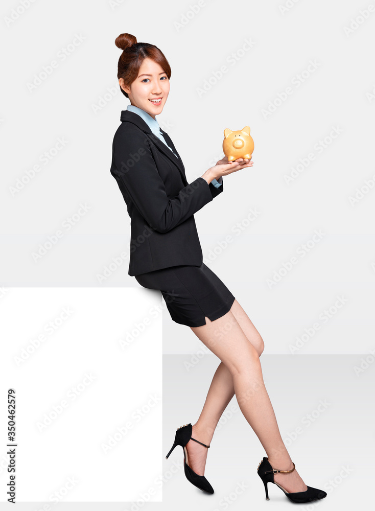 young Business woman sitting on blank billboard and showing the piggy bank young Business woman sitting on blank billboard and showing the piggy bank