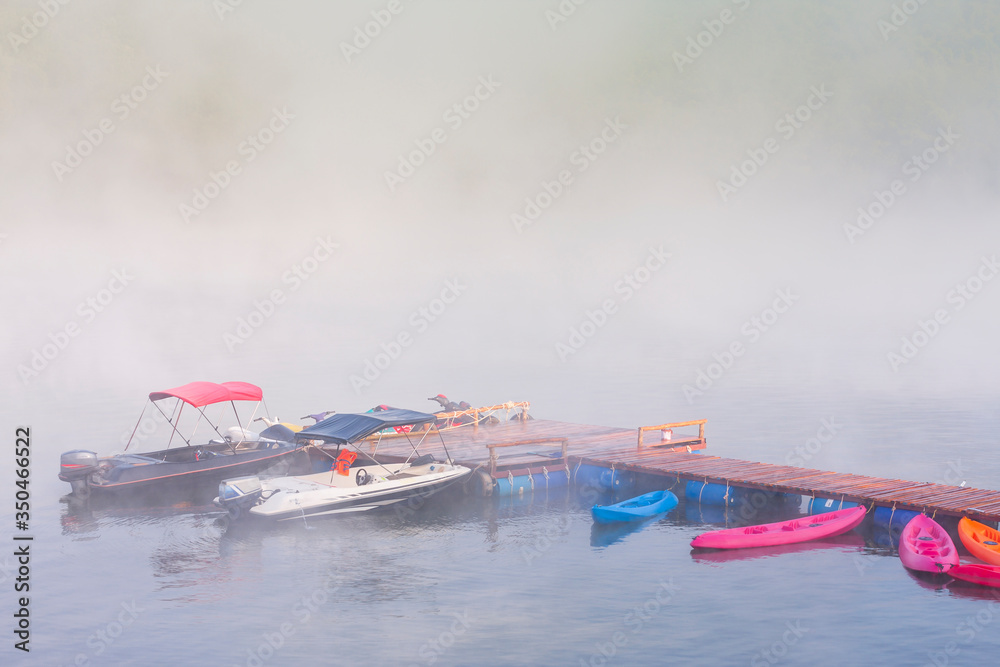 Foggy landscape with calm lake and pier.Mist over water. Beautiful freedom moment and peaceful atmosphere in nature.